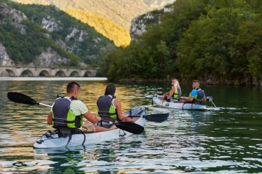 Bir grup arkadaş, sakin nehri, ormanı ve büyük doğal nehir kanyonlarını keşfederken eğleniyor ve kayak yapıyor.. 