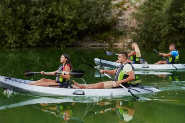 Bir grup arkadaş, sakin nehri, ormanı ve büyük doğal nehir kanyonlarını keşfederken eğleniyor ve kayak yapıyor.. 