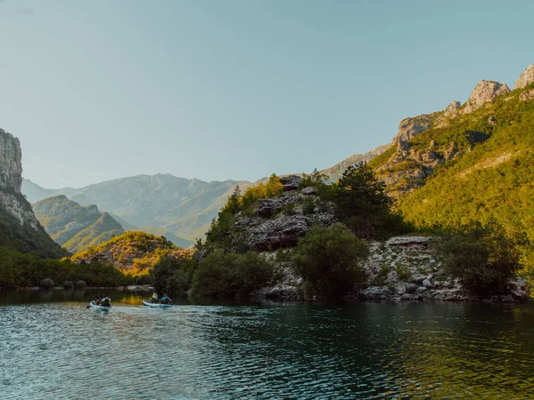 stock image A group of friends enjoying having fun and kayaking while exploring the calm river, surrounding forest and large natural river canyons. 