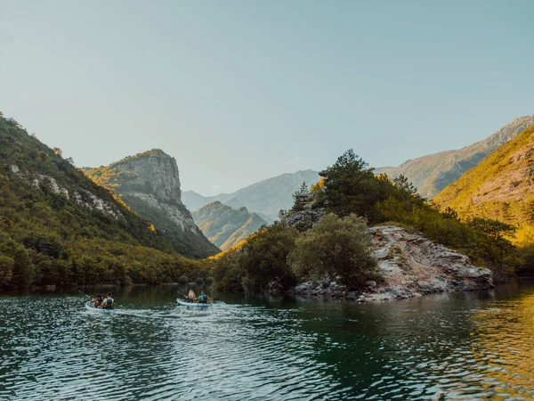 stock image A group of friends enjoying having fun and kayaking while exploring the calm river, surrounding forest and large natural river canyons. 