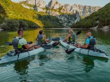 Bir grup arkadaş, sakin nehri, ormanı ve büyük doğal nehir kanyonlarını keşfederken eğleniyor ve kayak yapıyor..