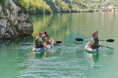 Bir grup arkadaş, sakin nehri, ormanı ve büyük doğal nehir kanyonlarını keşfederken eğleniyor ve kayak yapıyor.. 