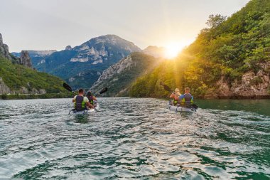 Bir grup arkadaş, sakin nehri, çevresindeki ormanı ve büyük doğal nehir kanyonlarını gezerek gün batımının keyfini çıkarıyorlar.