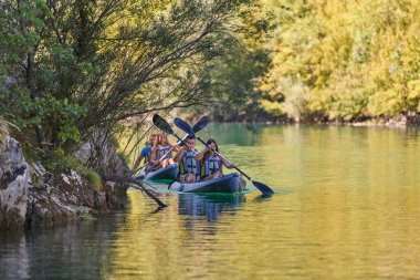 Bir grup arkadaş, sakin nehri, ormanı ve büyük doğal nehir kanyonlarını keşfederken eğleniyor ve kayak yapıyor.. 