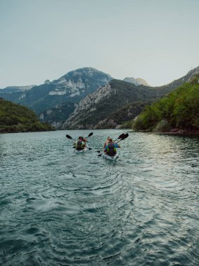 Bir grup arkadaş, sakin nehri, çevresindeki ormanı ve büyük doğal nehir kanyonlarını gezerek gün batımının keyfini çıkarıyorlar.