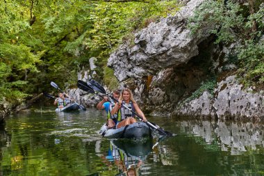 Bir grup arkadaş, sakin nehri, ormanı ve büyük doğal nehir kanyonlarını keşfederken eğleniyor ve kayak yapıyor.. 