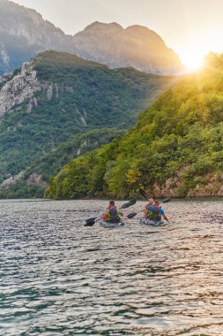Bir grup arkadaş, sakin nehri, çevresindeki ormanı ve büyük doğal nehir kanyonlarını gezerek gün batımının keyfini çıkarıyorlar.