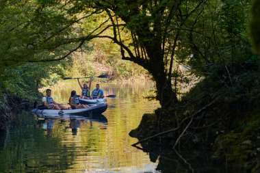 Bir grup arkadaş, sakin nehri, ormanı ve büyük doğal nehir kanyonlarını keşfederken eğleniyor ve kayak yapıyor.. 