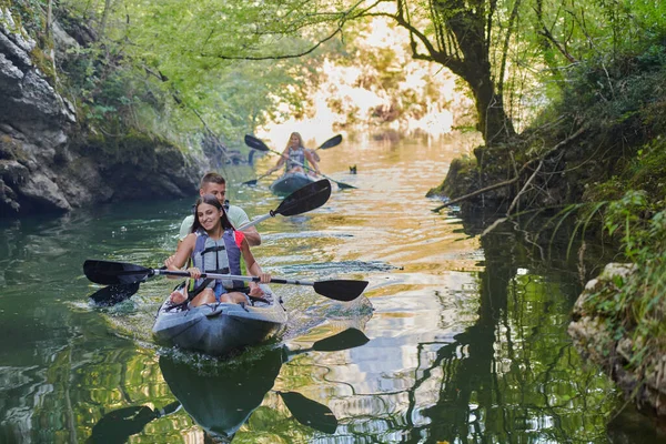 一群朋友在平静的河流 周围的森林和大峡谷中畅游 一边玩一边划皮划艇 — 图库照片