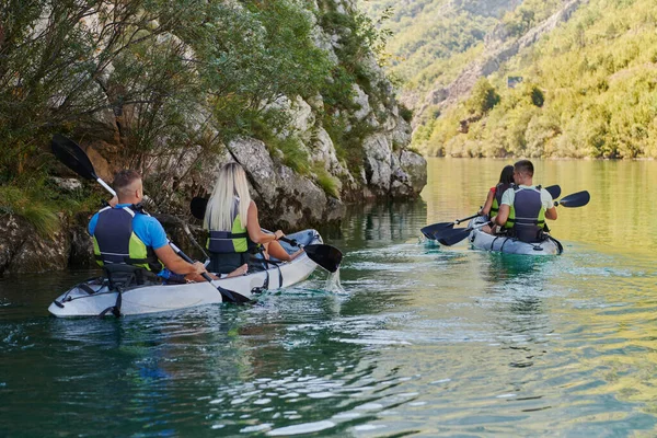 一群朋友在平静的河流 周围的森林和大峡谷中畅游 一边玩一边划皮划艇 — 图库照片