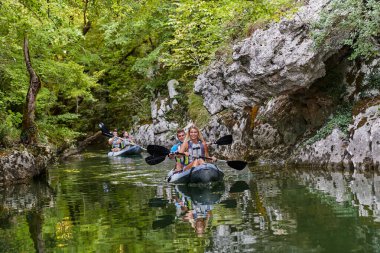 Bir grup arkadaş, sakin nehri, ormanı ve büyük doğal nehir kanyonlarını keşfederken eğleniyor ve kayak yapıyor.. 
