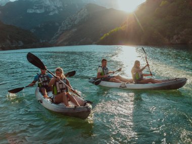 Bir grup arkadaş, sakin nehri, çevresindeki ormanı ve büyük doğal nehir kanyonlarını gezerek gün batımının keyfini çıkarıyorlar.