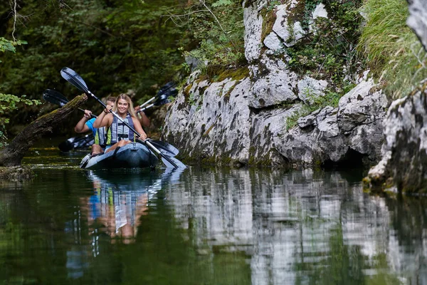 一对年轻夫妇在一条美丽的河流中享受着田园诗般的独木舟之旅 这条河流被茂密的绿叶环绕着 — 图库照片
