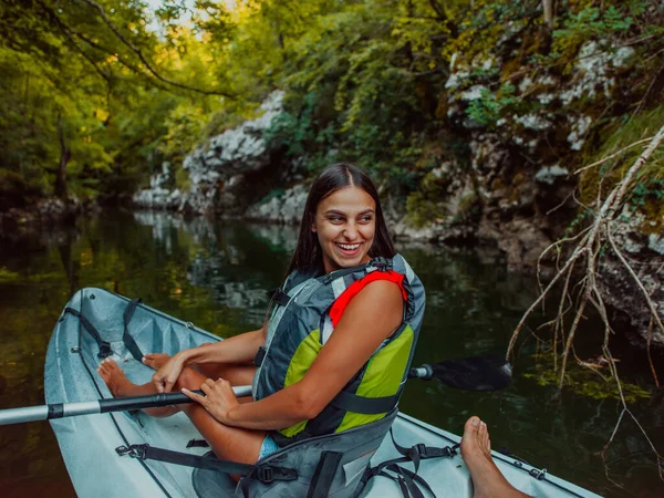 一位面带微笑的女人与朋友一起在河上峡谷探险 享受轻松自在的皮划艇之旅 — 图库照片