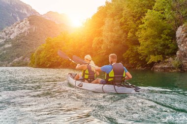Bir grup arkadaş, sakin nehri, çevresindeki ormanı ve büyük doğal nehir kanyonlarını gezerek gün batımının keyfini çıkarıyorlar.