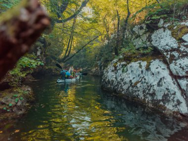 Bir grup arkadaş, sakin nehri, ormanı ve büyük doğal nehir kanyonlarını keşfederken eğleniyor ve kayak yapıyor.. 