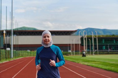 Çarşaf giymiş Müslüman bir kadın, spor kıyafetleriyle maraton koşuyor ve yaklaşan müsabakalara hazırlanıyor.. 