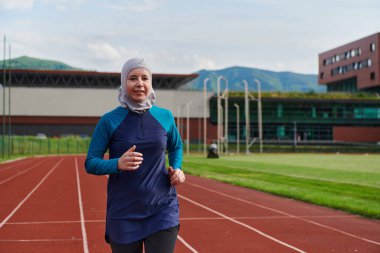 Çarşaf giymiş Müslüman bir kadın, spor kıyafetleriyle maraton koşuyor ve yaklaşan müsabakalara hazırlanıyor.. 