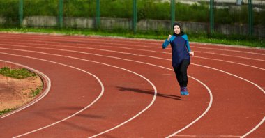 Çarşaf giymiş Müslüman bir kadın, spor kıyafetleriyle maraton koşuyor ve yaklaşan müsabakalara hazırlanıyor.. 