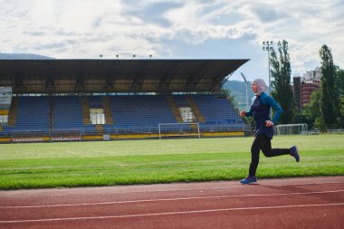 Çarşaf giymiş Müslüman bir kadın, spor kıyafetleriyle maraton koşuyor ve yaklaşan müsabakalara hazırlanıyor.. 