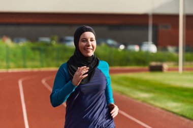 Çarşaf giymiş Müslüman bir kadın, spor kıyafetleriyle maraton koşuyor ve yaklaşan müsabakalara hazırlanıyor.. 