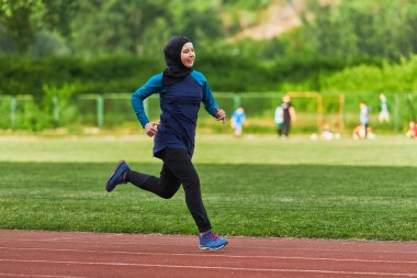 Çarşaf giymiş Müslüman bir kadın, spor kıyafetleriyle maraton koşuyor ve yaklaşan müsabakalara hazırlanıyor.. 