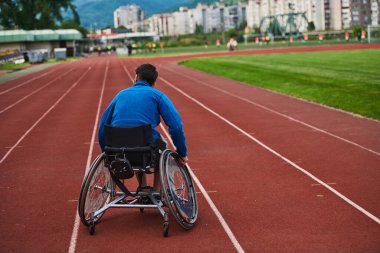 Engelli olimpiyatlarına hazırlanmak için tekerlekli sandalye eğitiminde yorulmadan pistte duran biri.