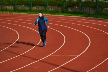 Çarşaf giymiş Müslüman bir kadın, spor kıyafetleriyle maraton koşuyor ve yaklaşan müsabakalara hazırlanıyor.. 