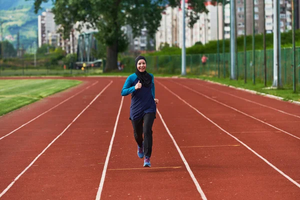 A muslim woman in a burqa sports muslim clothes running on a marathon course and preparing for upcoming competitions.
