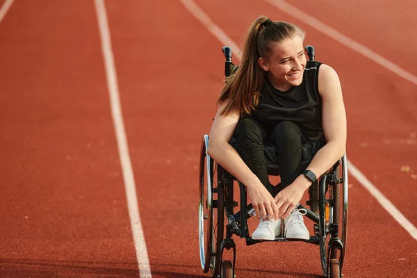 A woman with disablity driving a wheelchair on a track while preparing for the Paralympic Games.