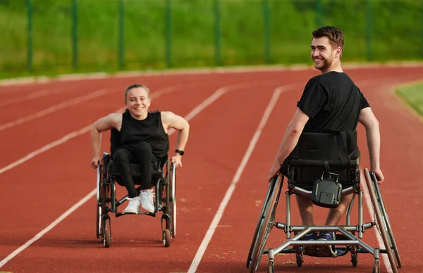 障害のある夫婦は マラソンコースで車椅子を押すパラリンピックのために一緒に訓練するときに 彼らの信じられないほどの決意と強さを示しています — ストック写真
