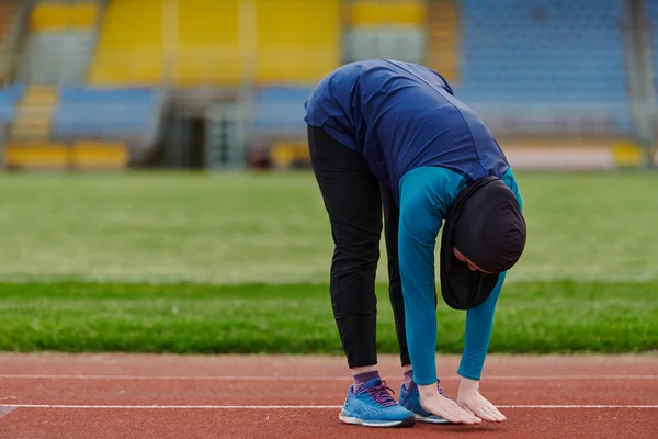 一名身穿伊斯兰运动服的穆斯林女子在马拉松赛赛程上进行了艰苦的训练 并在训练后伸长了脖子 腿和背进行了身体锻炼 — 图库照片