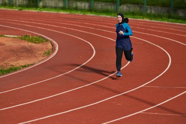 Çarşaf giymiş Müslüman bir kadın, spor kıyafetleriyle maraton koşuyor ve yaklaşan müsabakalara hazırlanıyor.. 