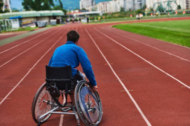 Engelli olimpiyatlarına hazırlanmak için tekerlekli sandalye eğitiminde yorulmadan pistte duran biri.