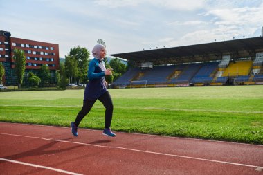 Çarşaf giymiş Müslüman bir kadın, spor kıyafetleriyle maraton koşuyor ve yaklaşan müsabakalara hazırlanıyor.. 