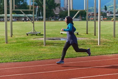 Çarşaf giymiş Müslüman bir kadın, spor kıyafetleriyle maraton koşuyor ve yaklaşan müsabakalara hazırlanıyor.. 