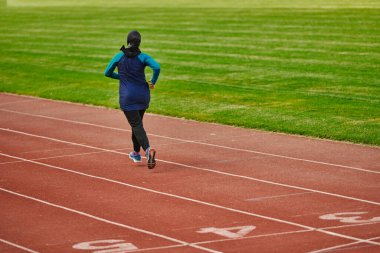 Çarşaf giymiş Müslüman bir kadın, spor kıyafetleriyle maraton koşuyor ve yaklaşan müsabakalara hazırlanıyor.. 