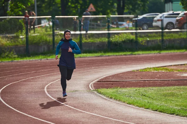 一名身穿布卡运动穆斯林服装的穆斯林女子在马拉松赛跑道上跑步 为即将到来的比赛做准备 — 图库照片