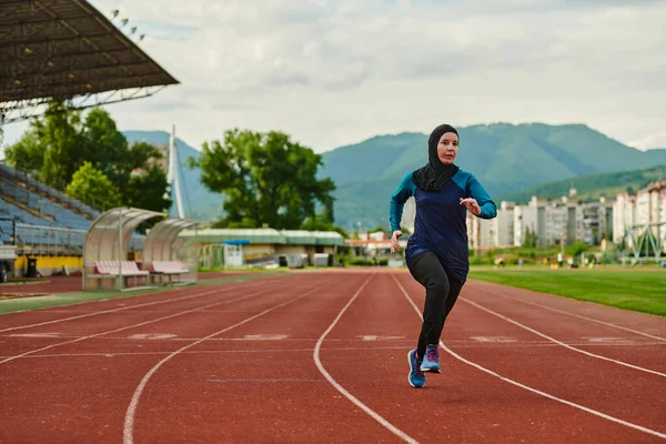 A muslim woman in a burqa sports muslim clothes running on a marathon course and preparing for upcoming competitions.
