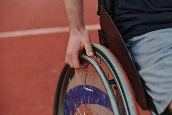 Close up photo of a person with disability in a wheelchair training tirelessly on the track in preparation for the Paralympic Games.