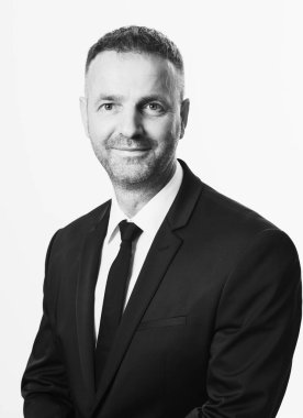 Başarıya alışığım. Kendine güvenen genç işadamı gri arka planda dikilirken ceketini ayarlıyor ve gözünü kaçırıyor. Yüksek kalite fotoğraf