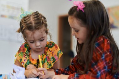 Kreş enstitüsünde oturan yaratıcı çocuklar eğitim alırken resim çizip eğleniyorlar. Yüksek kalite fotoğraf