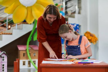 Bir kreşteki sanat dersinde yaratıcı çocuklar ya da ilkokul sınıfında bayan öğretmenle resim çizen çocuklar. Yüksek kalite fotoğraf