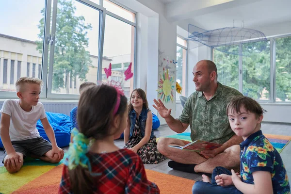 小学校や幼稚園での読書時間 小学校や幼稚園の子どもたちに本を読んでいる先生 就学前教育の概念 選択的焦点 — ストック写真