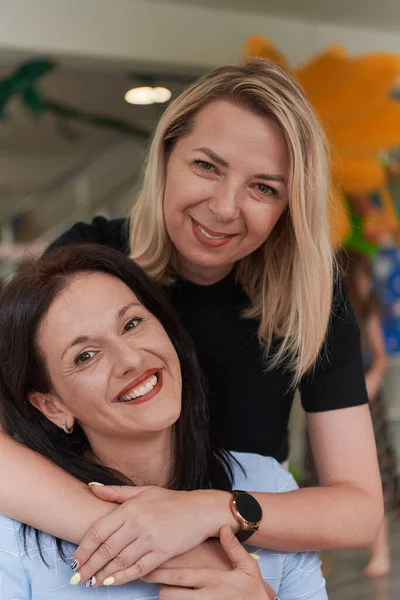 Two Women Share Heartfelt Embrace While Preschool Showcasing Nurturing Supportive — Stock Photo, Image