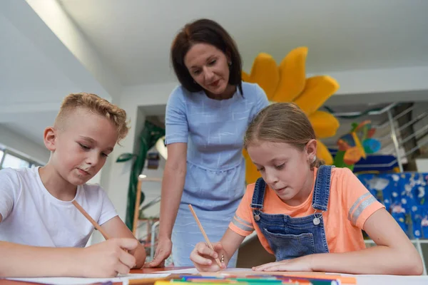 在日托中心的艺术课或小学课堂上与女教师一起画画时 有创意的孩子 — 图库照片