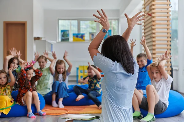 Una Maestra Felice Seduta Che Gioca Con Gruppo Scolaretti — Foto Stock