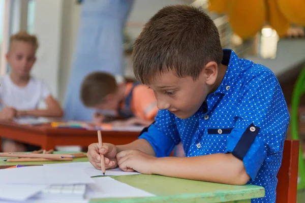 Ένα Αγόρι Ένα Νηπιαγωγείο Κάθεται Και Ζωγραφίζει Ένα Σημειωματάριο Ένα — Φωτογραφία Αρχείου