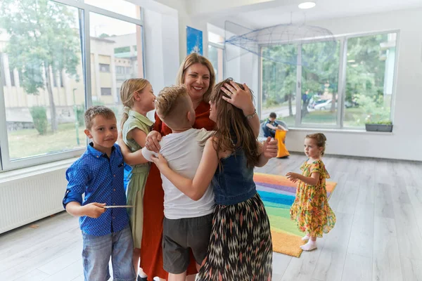 現代の幼稚園の先生を抱きしめる子供 高品質の写真 — ストック写真