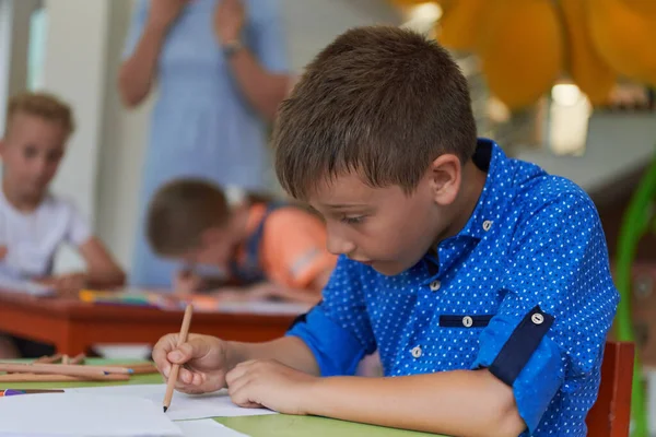Niño Una Institución Preescolar Sienta Dibuja Cuaderno Con Una Sonrisa — Foto de Stock